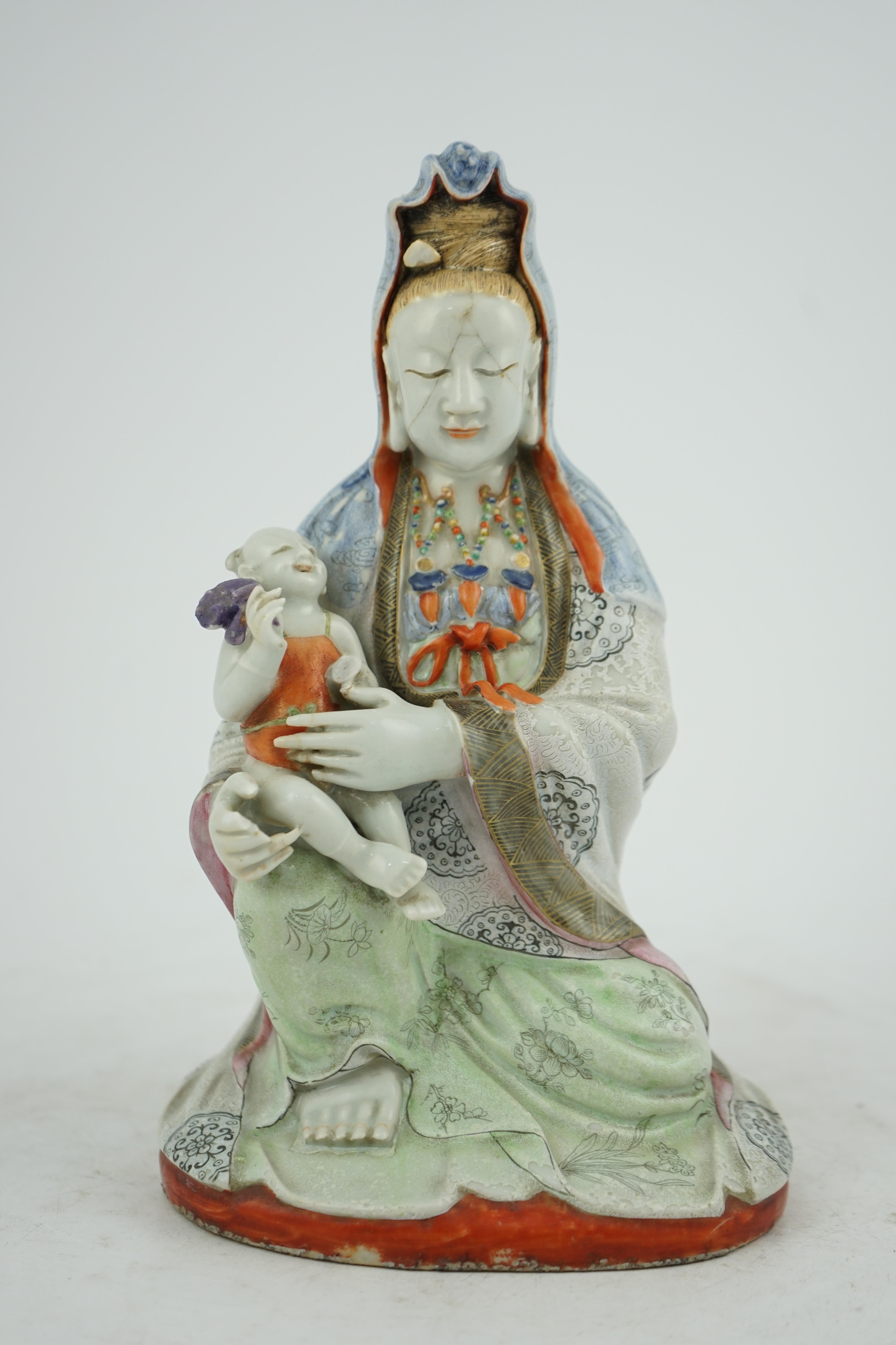 A Chinese enamelled porcelain group of Guanyin holding a child, Qianlong period